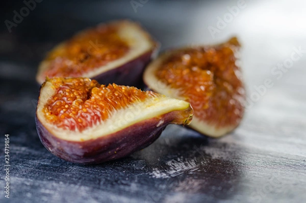 Fototapeta Figs on a dark wood background. selective focus on the figs slice