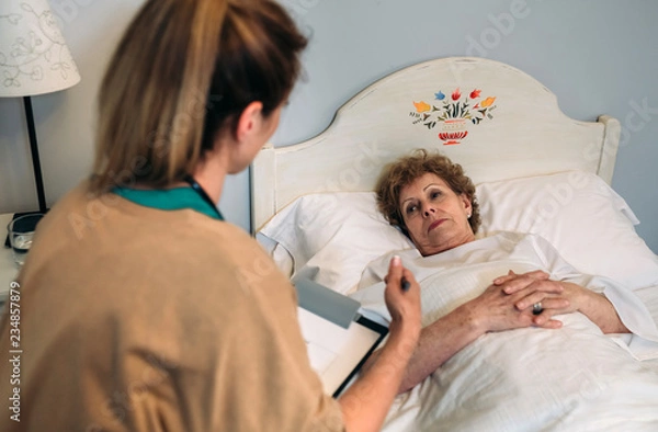 Fototapeta Female doctor explaining the treatment to a senior patient