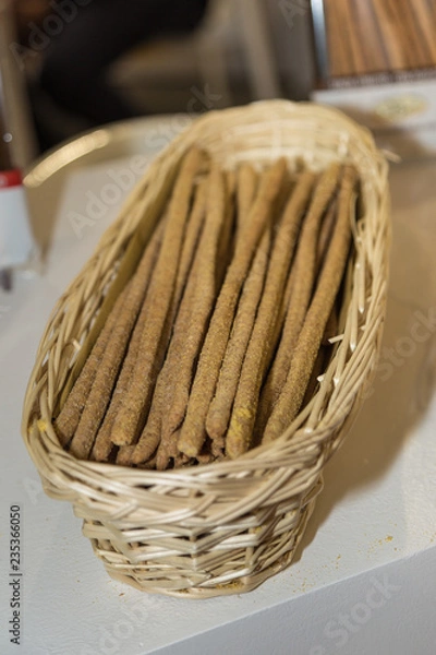 Fototapeta Long Crispy Breadsticks inside a Wicker Basket