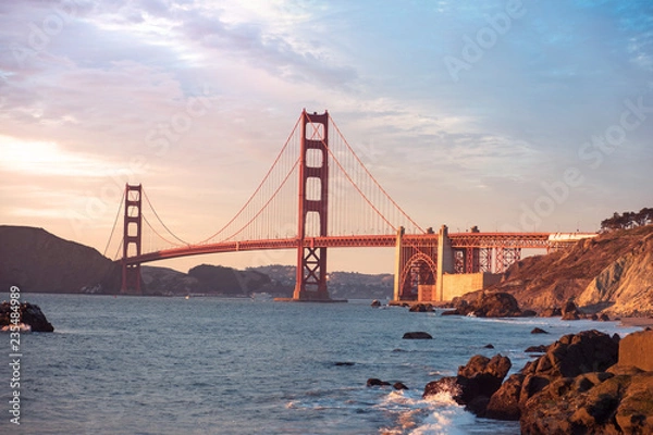 Fototapeta Classic panoramic view of famous Golden Gate Bridge seen from Baker Beach in beautiful golden evening light. San Francisco, California, USA