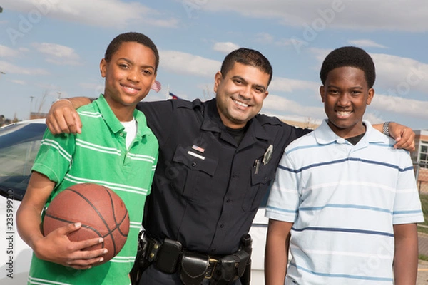 Fototapeta Policeman talking to kids on the street