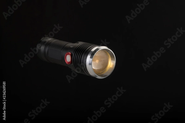 Fototapeta Tactical flashlight on a black background