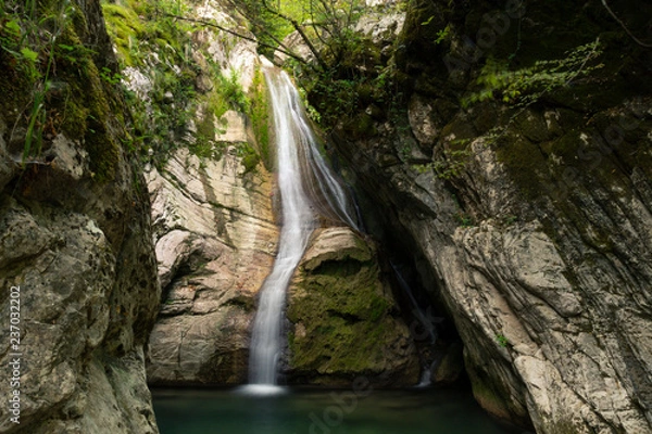 Fototapeta Small waterfall falling in a pond