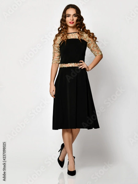 Fototapeta Young beautiful woman posing in new black fashion winter dress full body on a white 