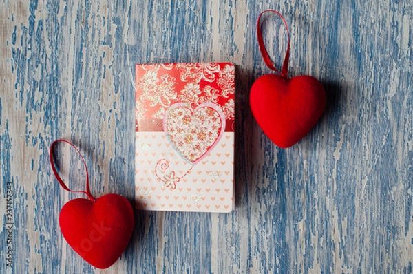 Fototapeta Valentine's day, background with space for copy. Postcard and red hearts on a wooden background