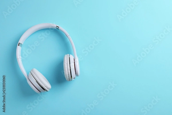 Fototapeta Wireless headphones on color background, top view. Space for text