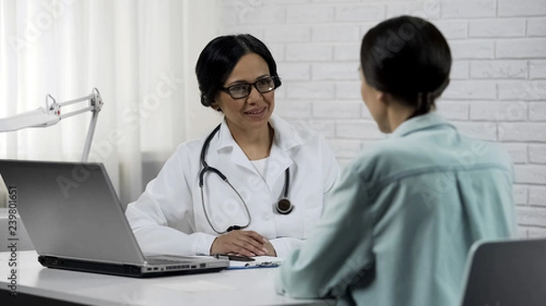 Fototapeta Friendly doctor talking to patient, promising to help, informing good results