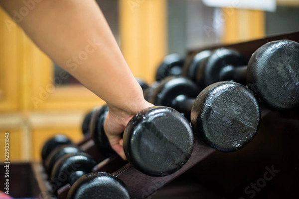 Fototapeta Hand  with dumbbells in gym concept.