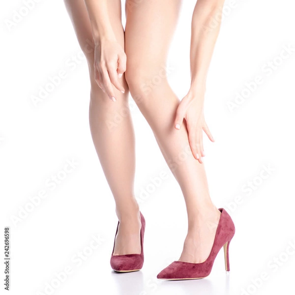 Fototapeta Female legs in red maroon high heel shoes leg hurts pain on white background. Isolation