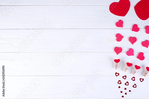 Fototapeta Valentine's day background with red hearts on wooden planks. View from above. Valentines Day concept