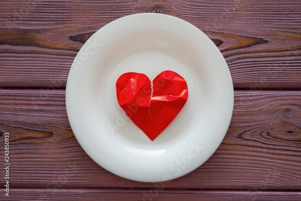 Fototapeta Torn heart on a plate. The concept of broken love, love suffering.