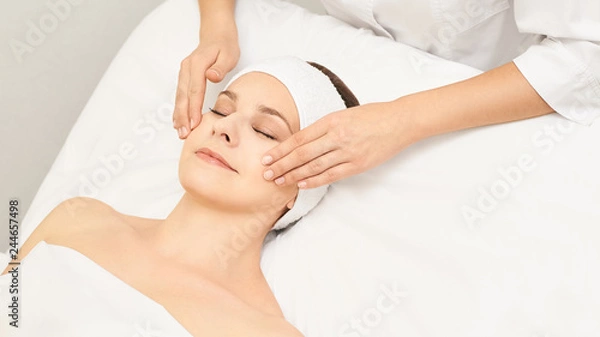 Fototapeta Face professional massage. Spa skincare treatment. Health facial masseur. Girl with doctor hands. Relax cosmetology procedure