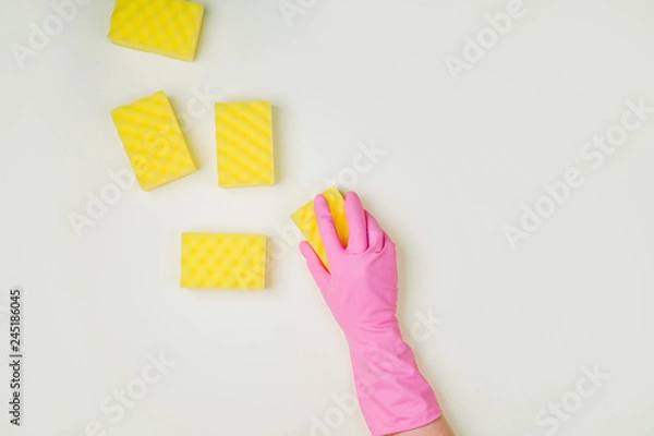 Fototapeta Female hands cleaning with sponge on yellow background. Cleaning or housekeeping concept background. Copy space. Flat lay, Top view.