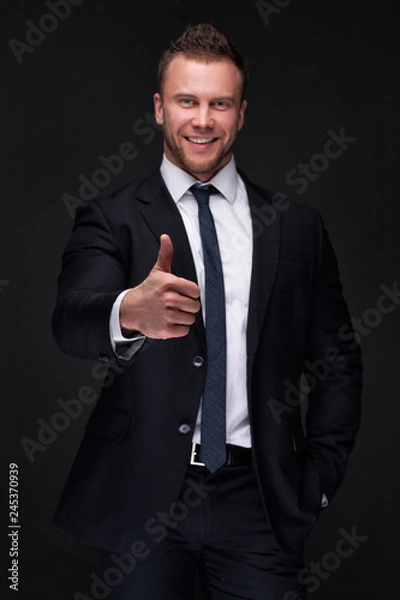 Obraz Portrait of young businessman showing thumbs up gesture