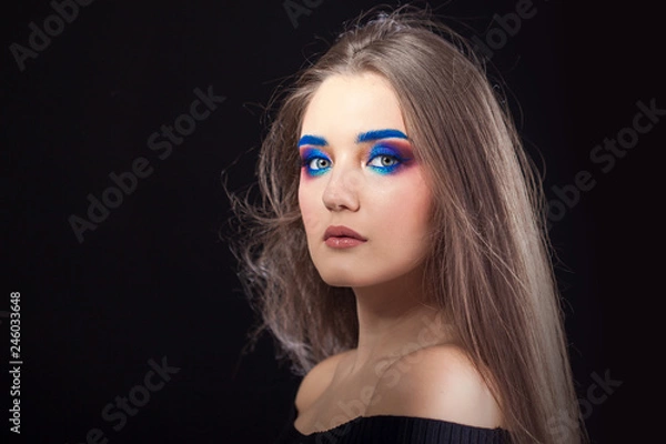 Fototapeta Attractive brunette with bright stylish make-up. Colored Smokey eyes and blue eyebrows.