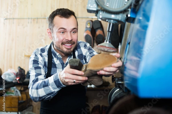 Fototapeta Male worker repairing shoe