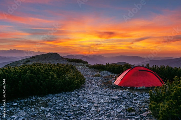 Fototapeta Tourists rest on a mountain ridge in a red tent in the Ukrainian Carpathians.