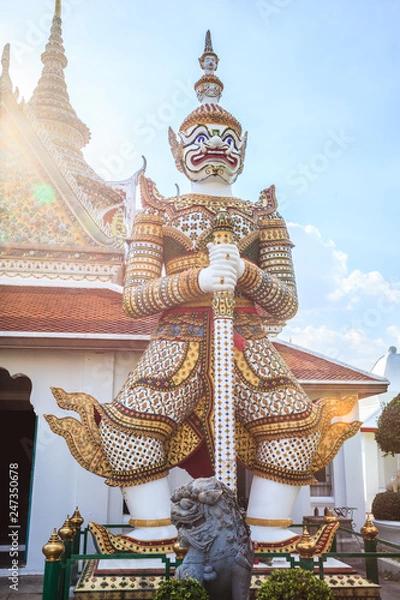 Fototapeta ancient temple guardian in front of Temple of Dawn (Wat Arun Buddhist Temple) is white demon giant statue named Sahatsadecha. Thailand Traditional Tourist Attraction, Thai Travel and Tourism concept