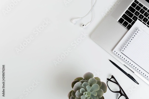 Fototapeta Top View of trendy White Office Desk with keyboard, white earphones and office supplies.