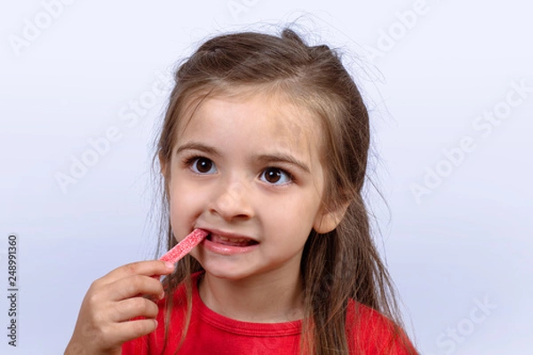 Obraz Little girl eating sweet candy.