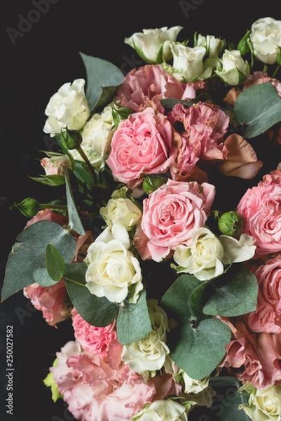 Fototapeta Bouquet of roses and eucalyptus over black background. Wedding, birthday flowers bouquet