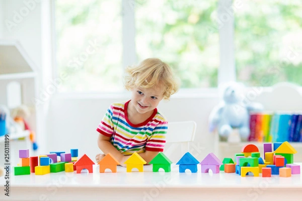 Fototapeta Kids toys. Child building tower of toy blocks.