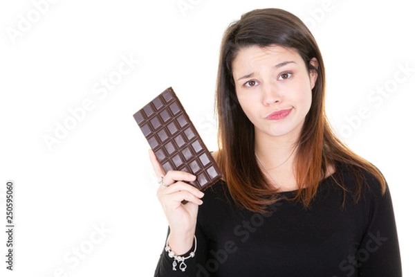 Fototapeta cute young woman with big bar of chocolate looking at it with temptation