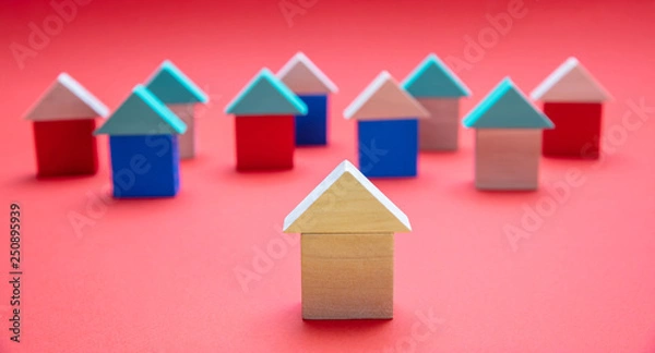 Fototapeta  One house model ahead of the others, red color background