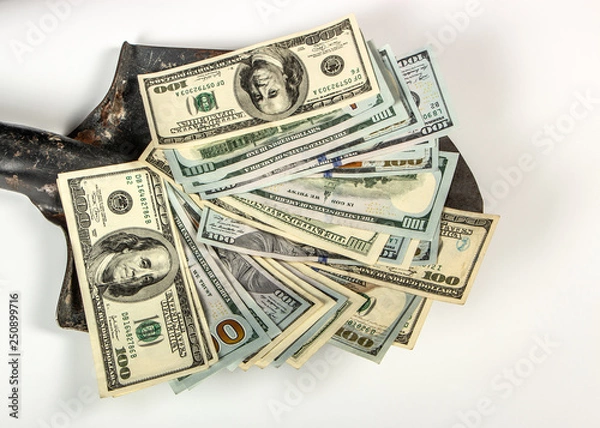 Fototapeta Money, one hundred dollars, banknotes on an old construction shovel, on a white background.