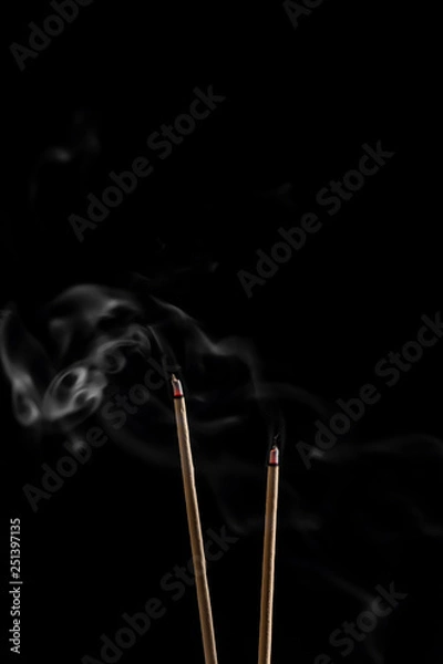 Fototapeta Incense sticks and incense stick smoke on black backgrond