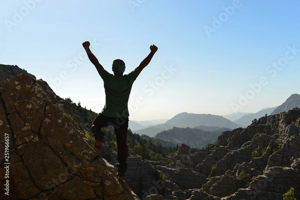 Fototapeta triumph of successful mountaineer in mystic mountains