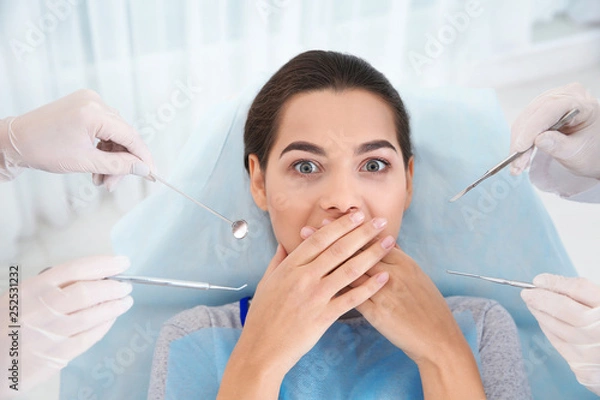 Fototapeta Young woman scared of dental examination in clinic