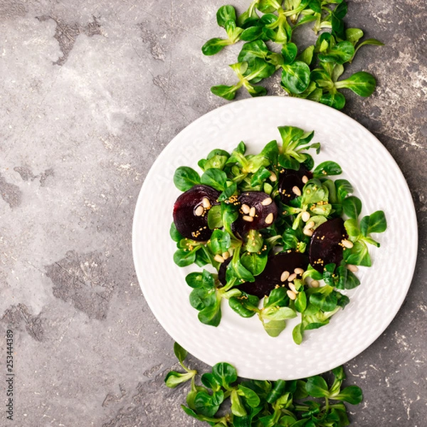 Obraz Easy vegetarian salad with fresh vegetables and young greens on white dish. The concept of healthy and proper nutrition.