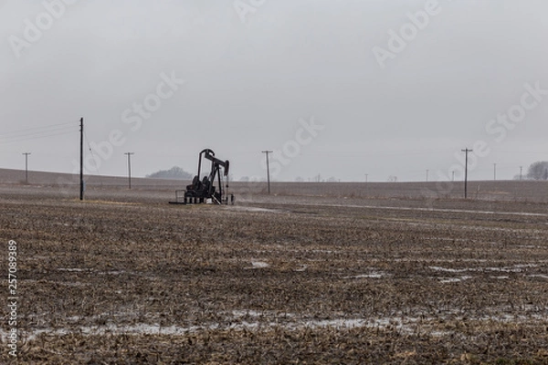 Fototapeta Drilling rig rotating on farmland deep in the midwest