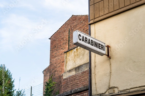 Fototapeta Chiusi, Italy Empty street in small town village in Umbria Tuscany during day with Italian police Carabinieri sign