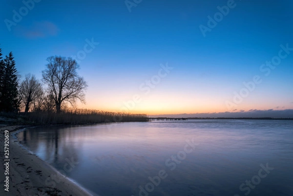 Fototapeta Sunset or sunrise on the beach on the island of Ruegen on the Baltic Sea. Concept: postcards or vacation and travel