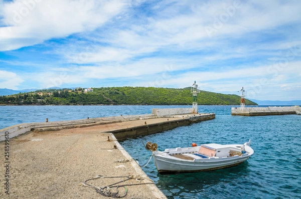 Fototapeta A traditional boat in the harbor with an island in the background