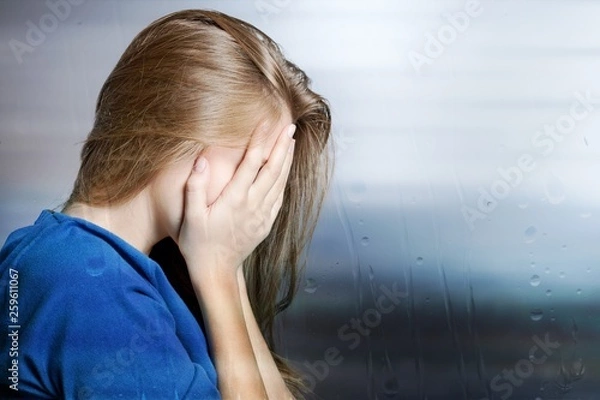 Fototapeta Young woman crying on background