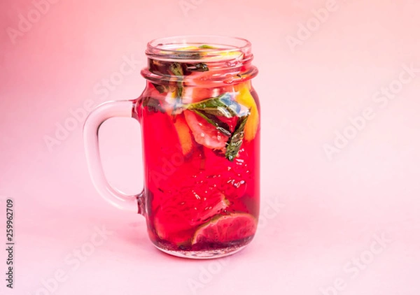 Fototapeta Jar of tasty cold lemonade on a pink background