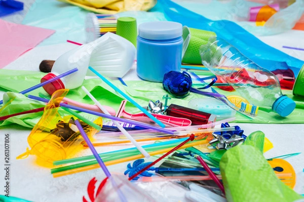 Fototapeta Close up of plastic bottle and packs lying near colorful straws