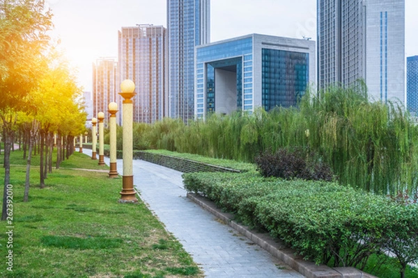 Fototapeta park pedestrian walkway and modern skyscrapers, dalian city, china.