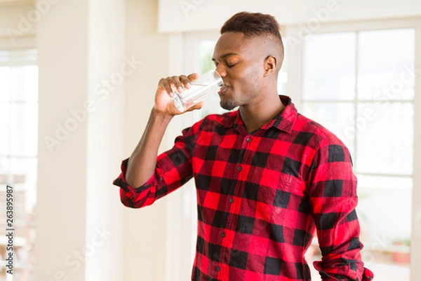 Fototapeta Young african american man drinking a fresh glass of water