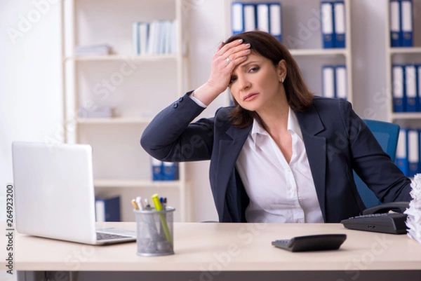 Fototapeta Middle-aged female employee suffering in the office 