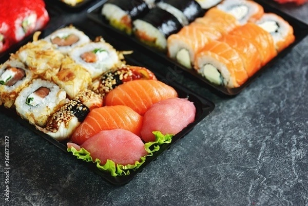 Fototapeta Sushi set with salmon, soft cheese, tuna, smoked eel. Sushi delivery to home. Healthy food. Top view. 