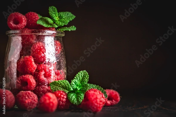 Fototapeta Raspberry. Raspberries and blueberries in a Cup on a dark background. Summer and healthy food concept. Background with copy space. Selective focus.