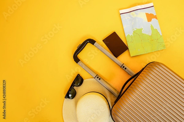 Obraz Flat lay yellow suitcase with traveler accessories sunglasses on yellow background. travel concept