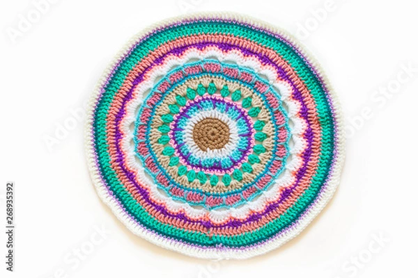 Fototapeta Round mandala crocheted from colored yarn. White background.