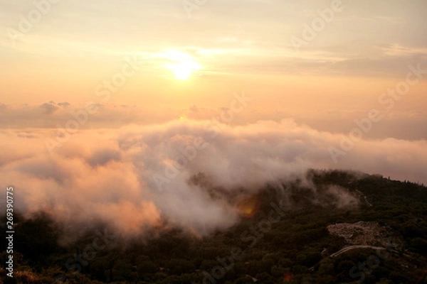 Fototapeta Beautiful structure of clouds on sky, mountain landscape with dense fog at sunset on horizon of beauty natural environment. Panorama of amazing sunrise view show sun rays through clouds over mountain.