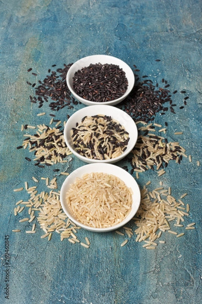 Fototapeta Bowls with uncooked black and white rice