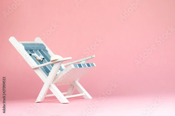 Fototapeta Sun lounger isolated on pink background. Tropical vacation background. Sun lounger on the sandy island, copy space, front view